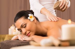 relaxed woman receiving a back massage at health spa